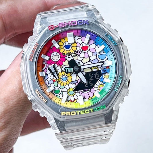 A customized G-Shock CasiOak watch with a sunflower pattern and rainbow colors on the dial, held in a person's hand.