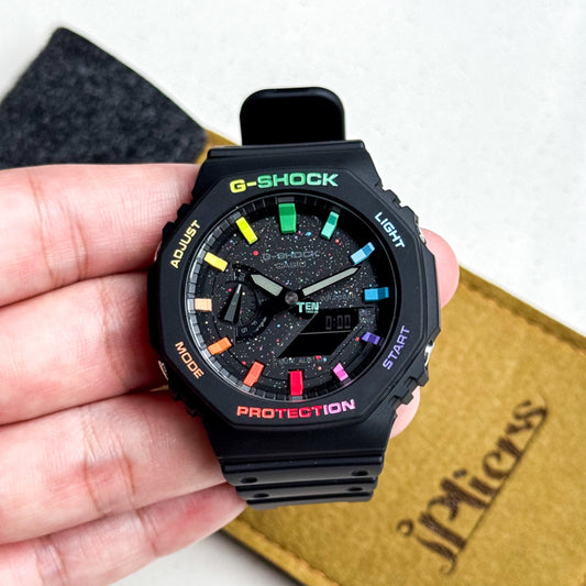 Black G-Shock watch held in a hand with a white background